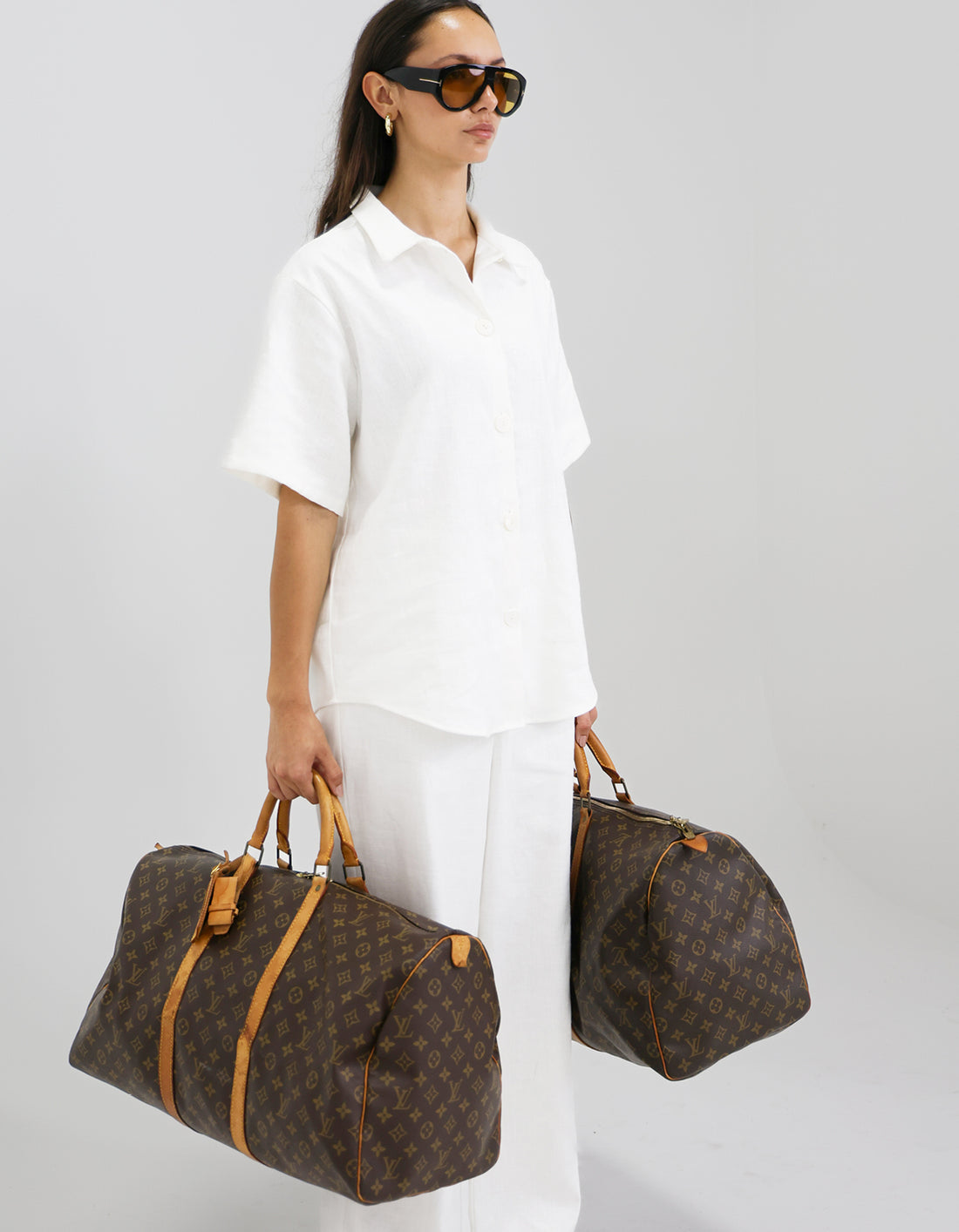 Woman holding two brown louis vuitton  bags