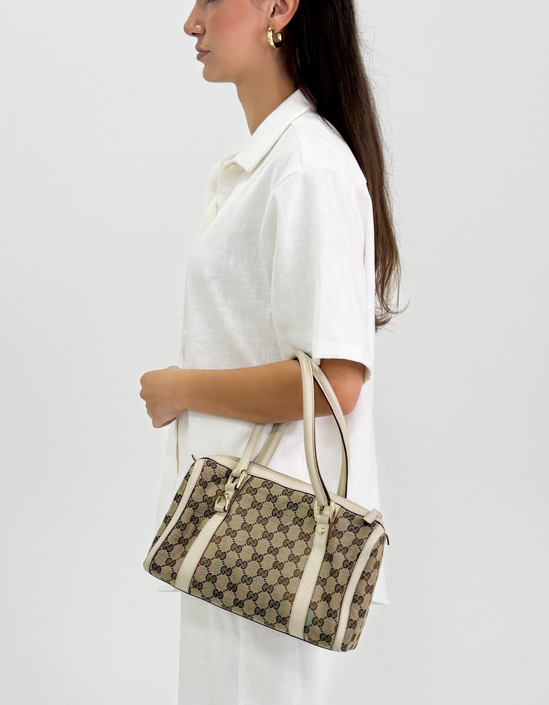 Woman holding a abbey gucci monogram handbag 